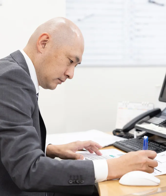 書類仕事中の男性社員の画像
